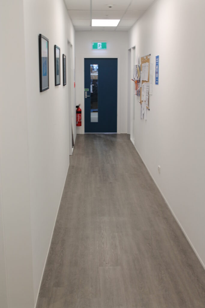 Briscoes HQ Morningside: Grey carpet in the open-plan office and grey timber-look planks in the kitchen and corridor