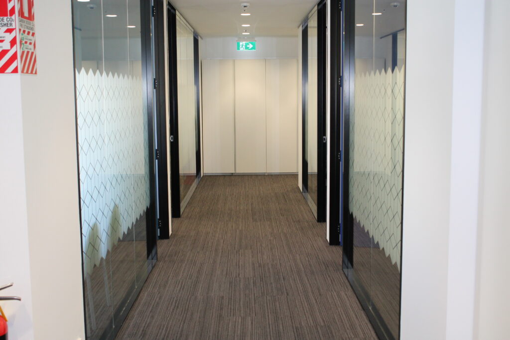 Briscoes HQ Morningside: Grey carpet in the open-plan office and grey timber-look planks in the kitchen and corridor