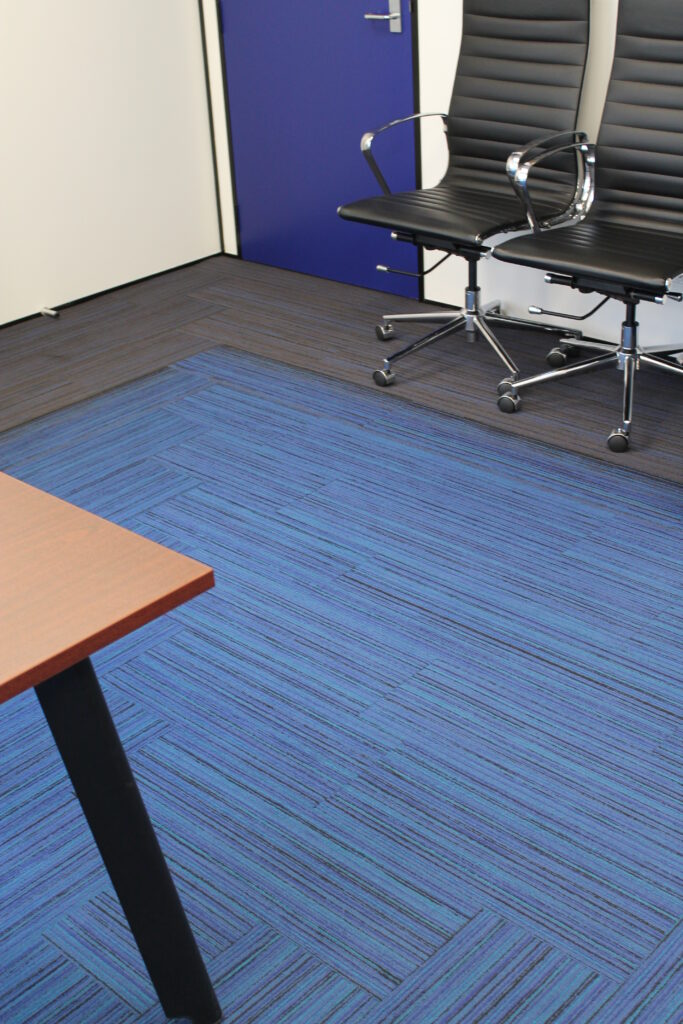 Briscoes HQ Morningside: Grey carpet in the open-plan office and grey timber-look planks in the kitchen and corridor