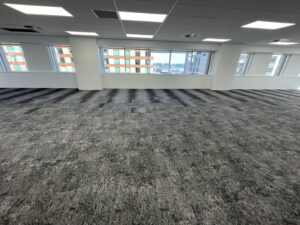 Open-plan office floor with grey carpet tile flooring