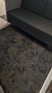 Dark patterned carpet tile flooring beside a bench seat
