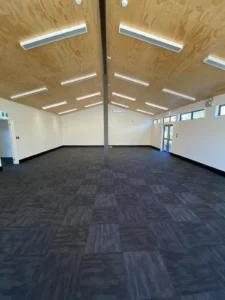 School classroom with dark carpet tile flooring and timber ceiling