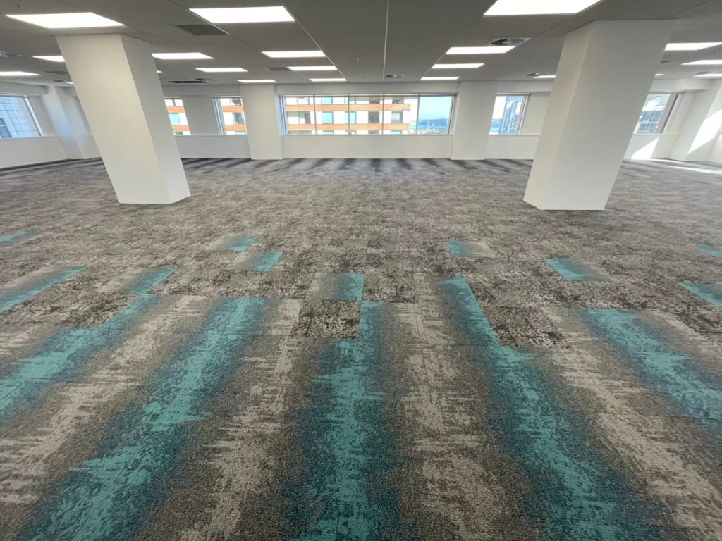 Open office floor with grey and teal striped carpet tile flooring