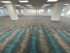 Open office floor with grey and teal striped carpet tile flooring